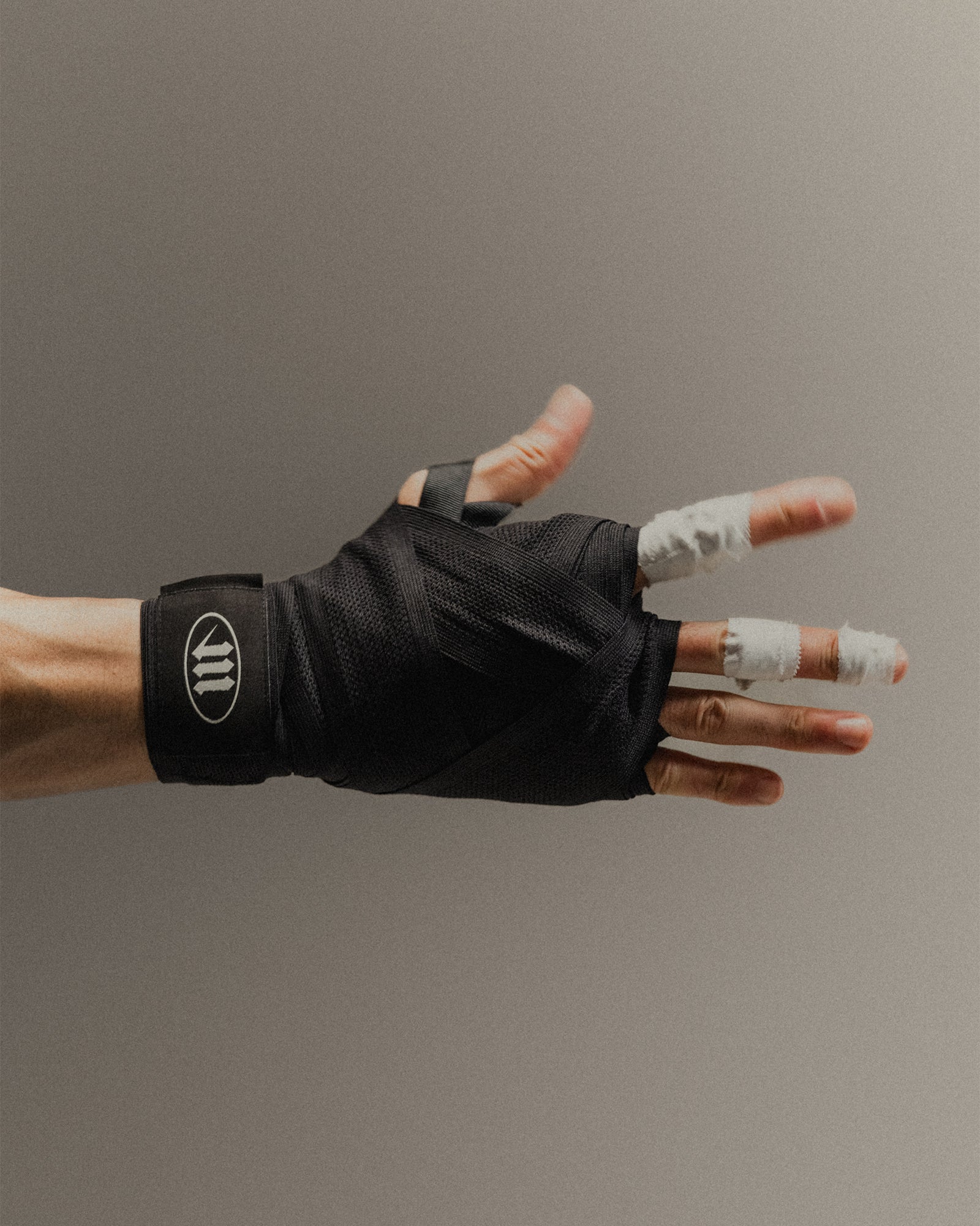 Close-up of a man's hand wearing black 'M' Logo boxing hand wraps