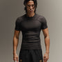 Man wearing black fight shorts and black Martial rashguard on a gray background