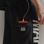 Up-close of side drop phone pocket on black 'Martial' sweatpants 