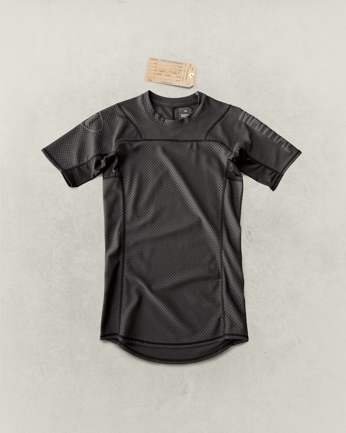 Black Martial rashguard laying on a light gray backdrop.